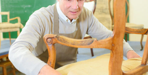 older man restoring a chair in his workshop